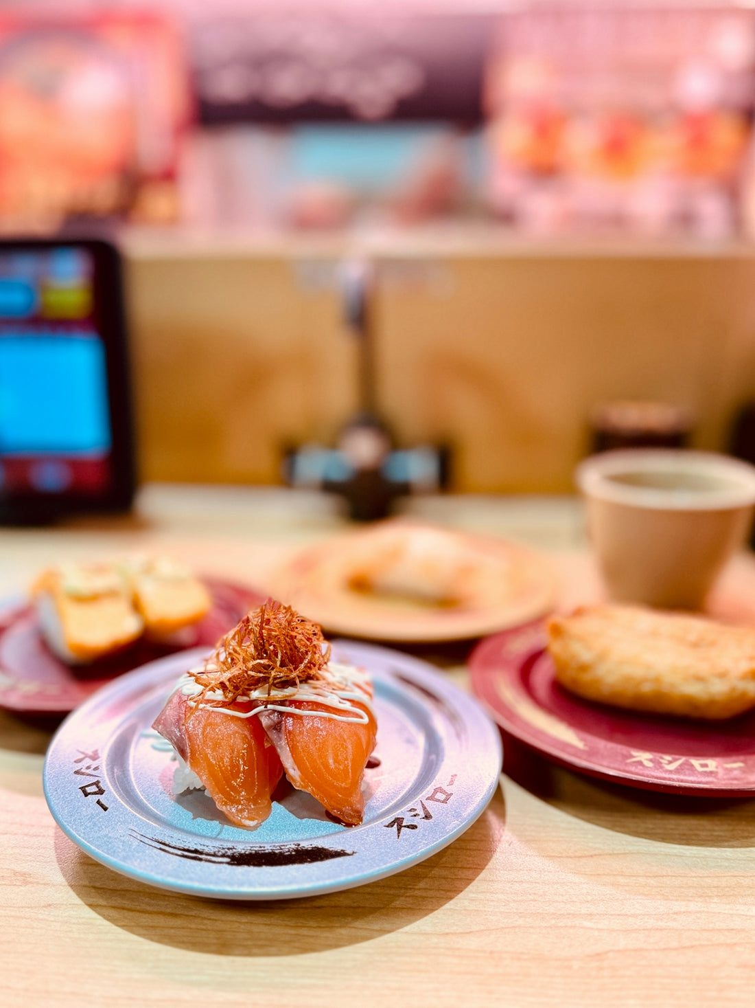 Salmon sushi with toppings on a plate.