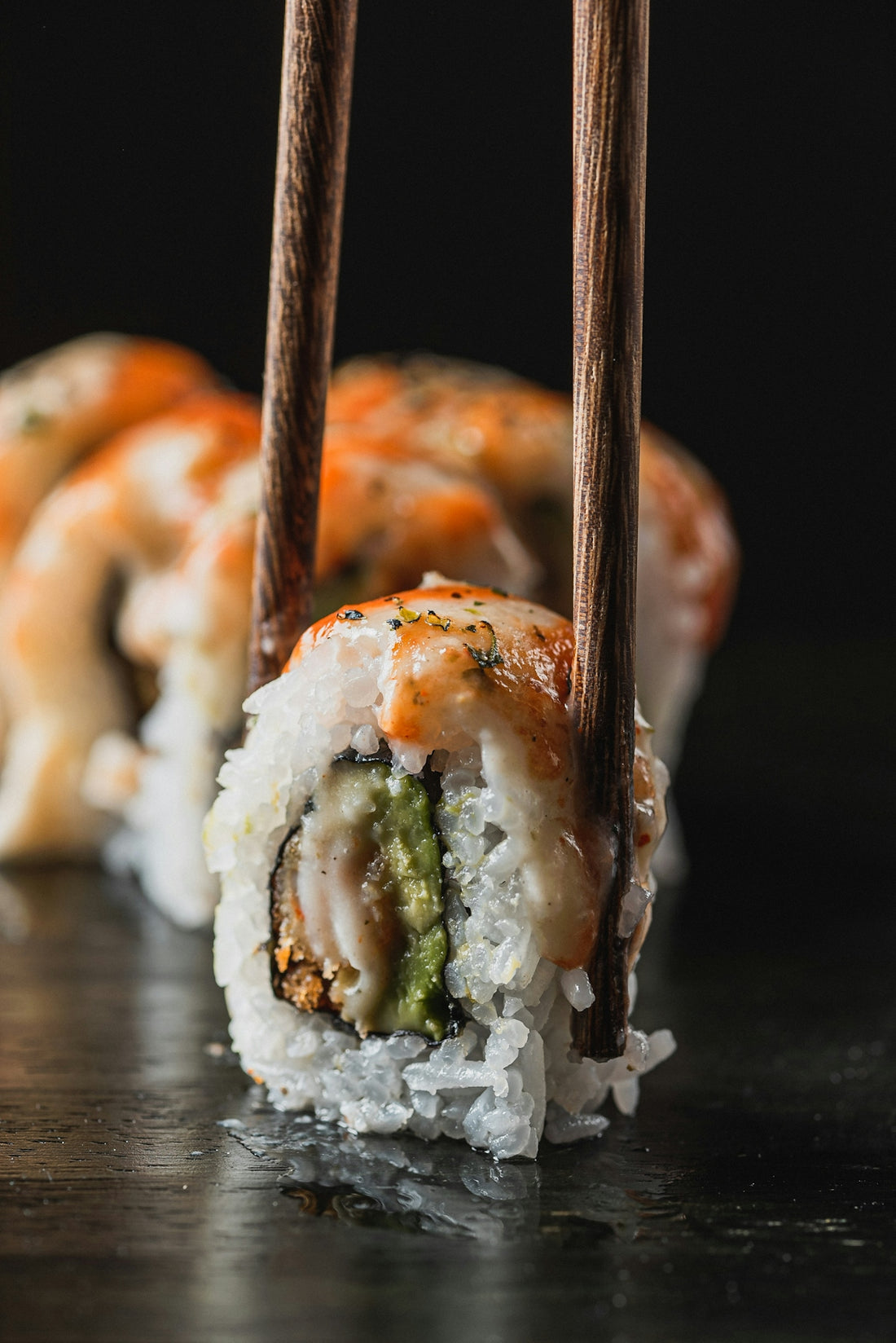 Chopsticks picking up a sushi roll