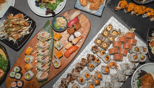 A variety of sushi rolls and nigiri arranged on platters.